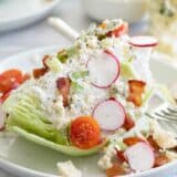 wedge salad on a plate topped with blue cheese dressing