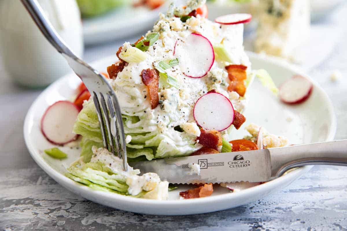 eating a wedge salad with a fork and a knife