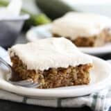 slice of zucchini cake on a plate with another plate behind it