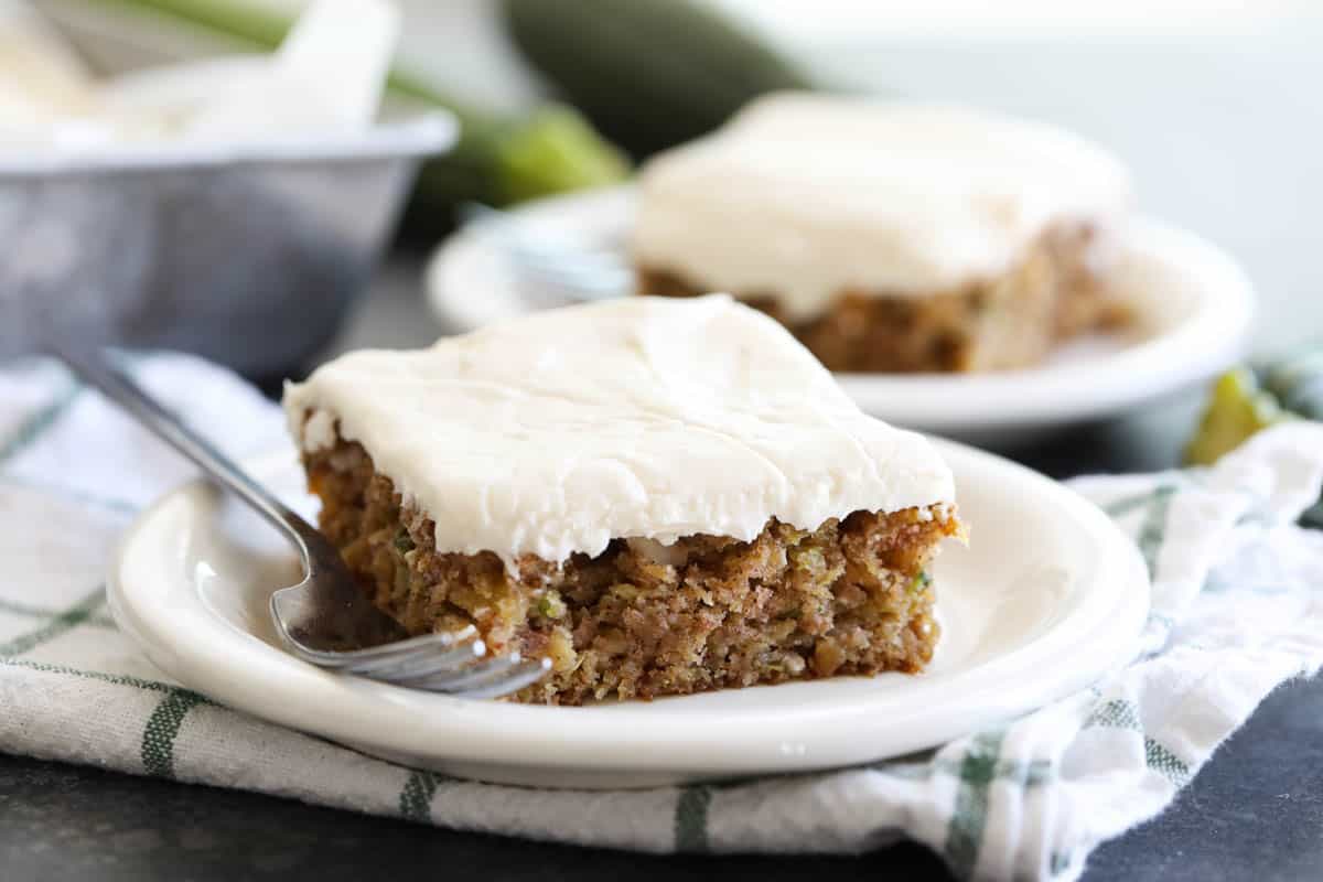 slice of zucchini cake on a plate with another plate behind it