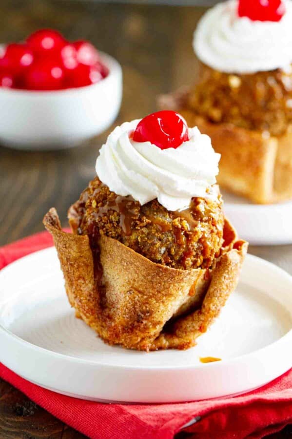 fried ice cream in a tortilla bowl sitting on a white plate