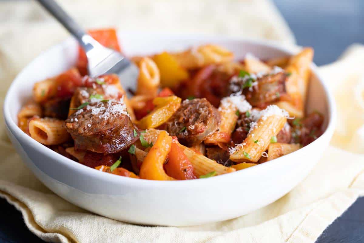 white bowl of sausage and peppers pasta