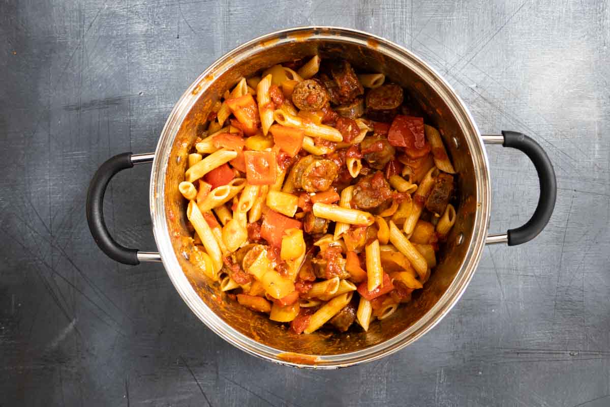 pot filled with pasta, peppers and sausage with sauce