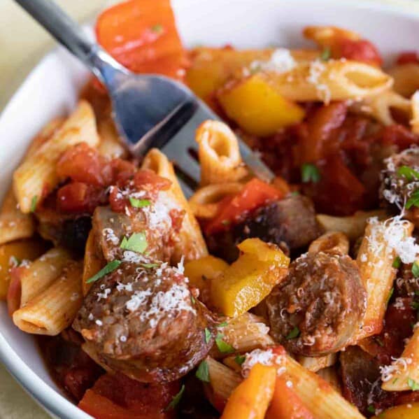 bowl of sausage and peppers pasta with a fork