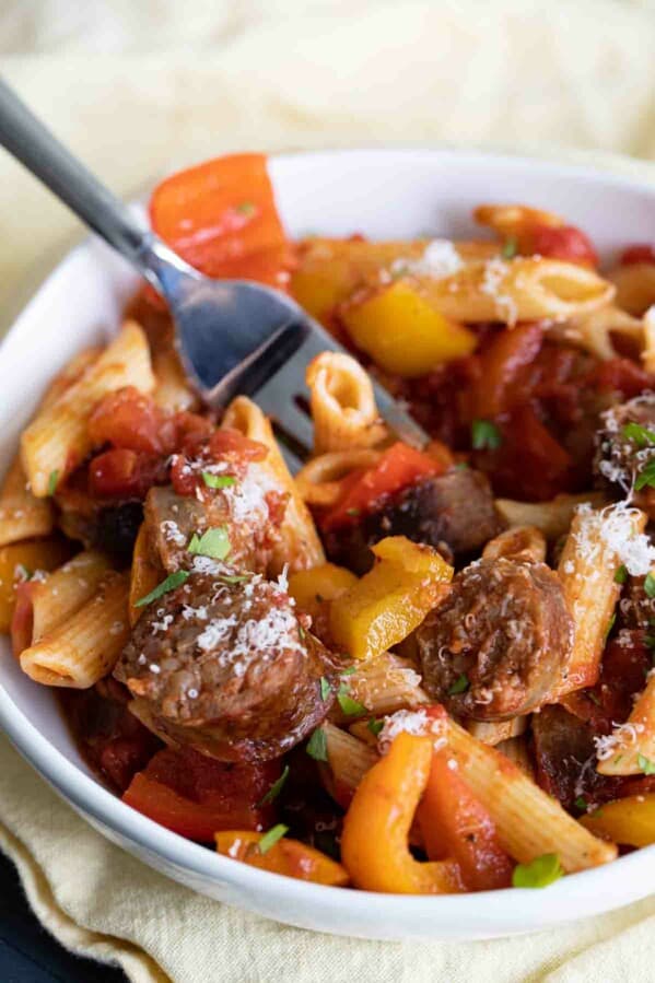 bowl of sausage and peppers pasta with a fork