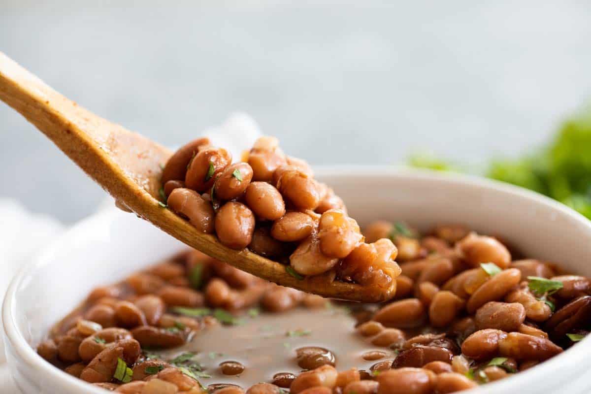 spoonful of beans with a wooden spoon