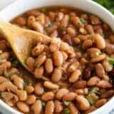 bowl of cooked pinto beans with cilantro on top