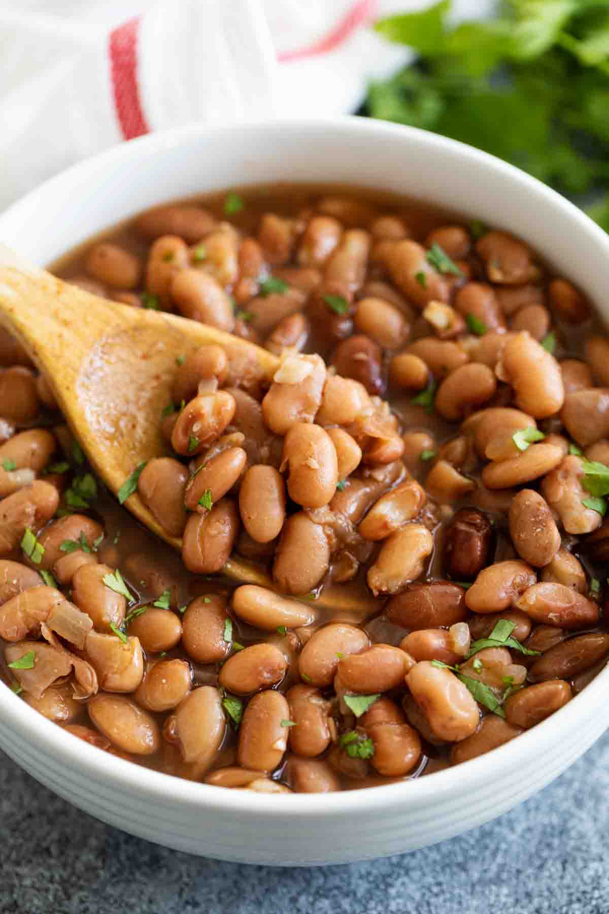bowl of cooked pinto beans with cilantro on top