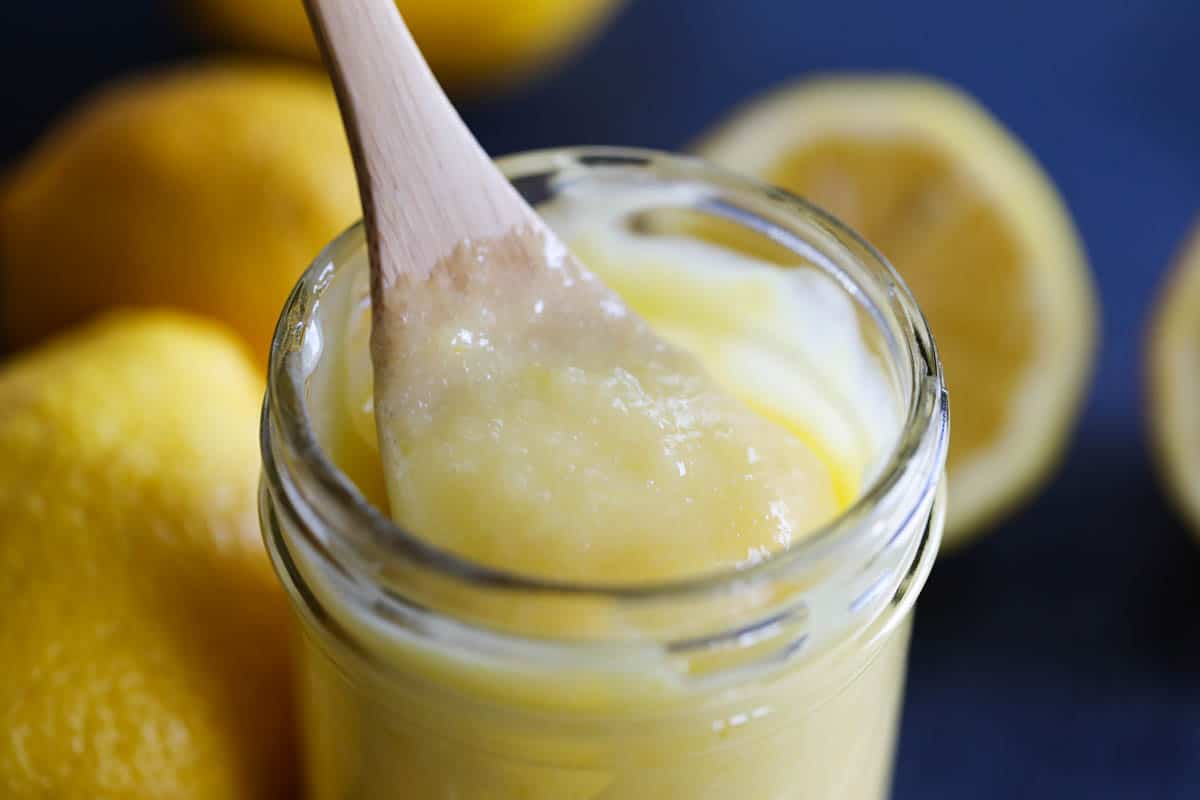 taking a spoonful of lemon curd with a spoon