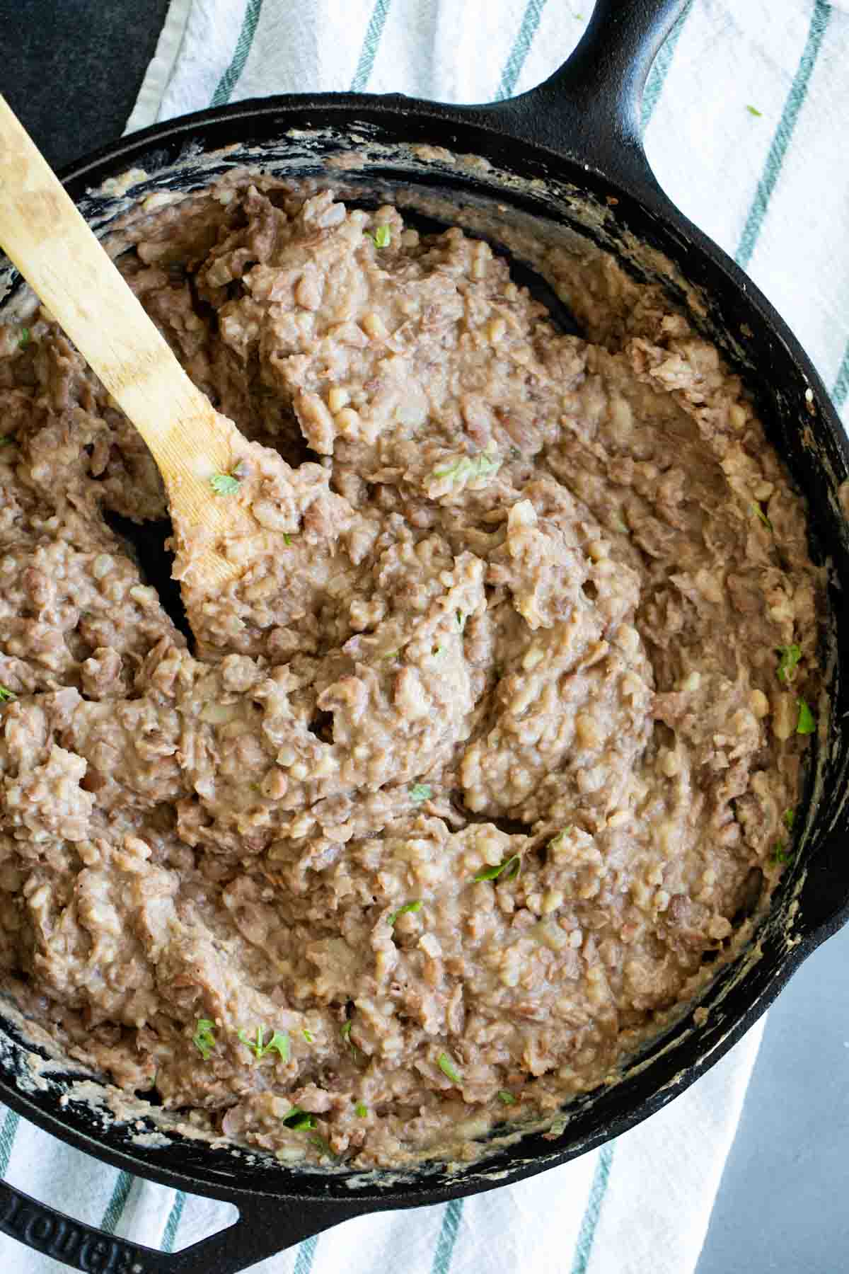 overhead view of refried beans in a cast iron skillet