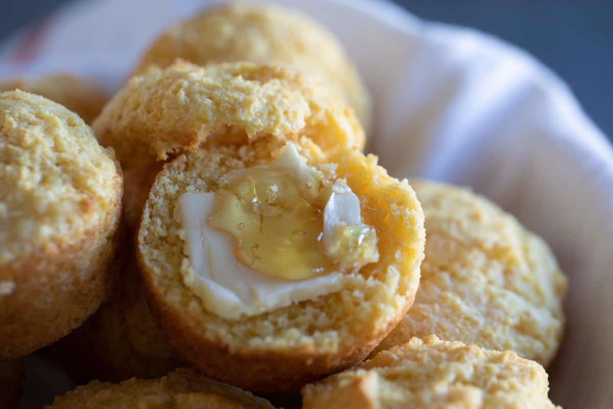 corn muffin cut open with butter and honey