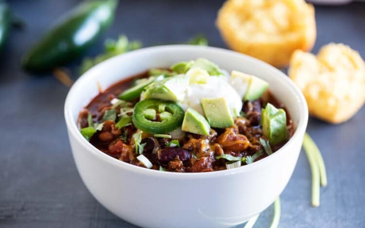 white bowl with crock pot chili with toppings