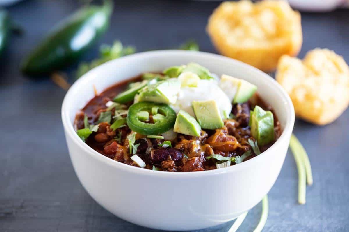 white bowl with crock pot chili with toppings