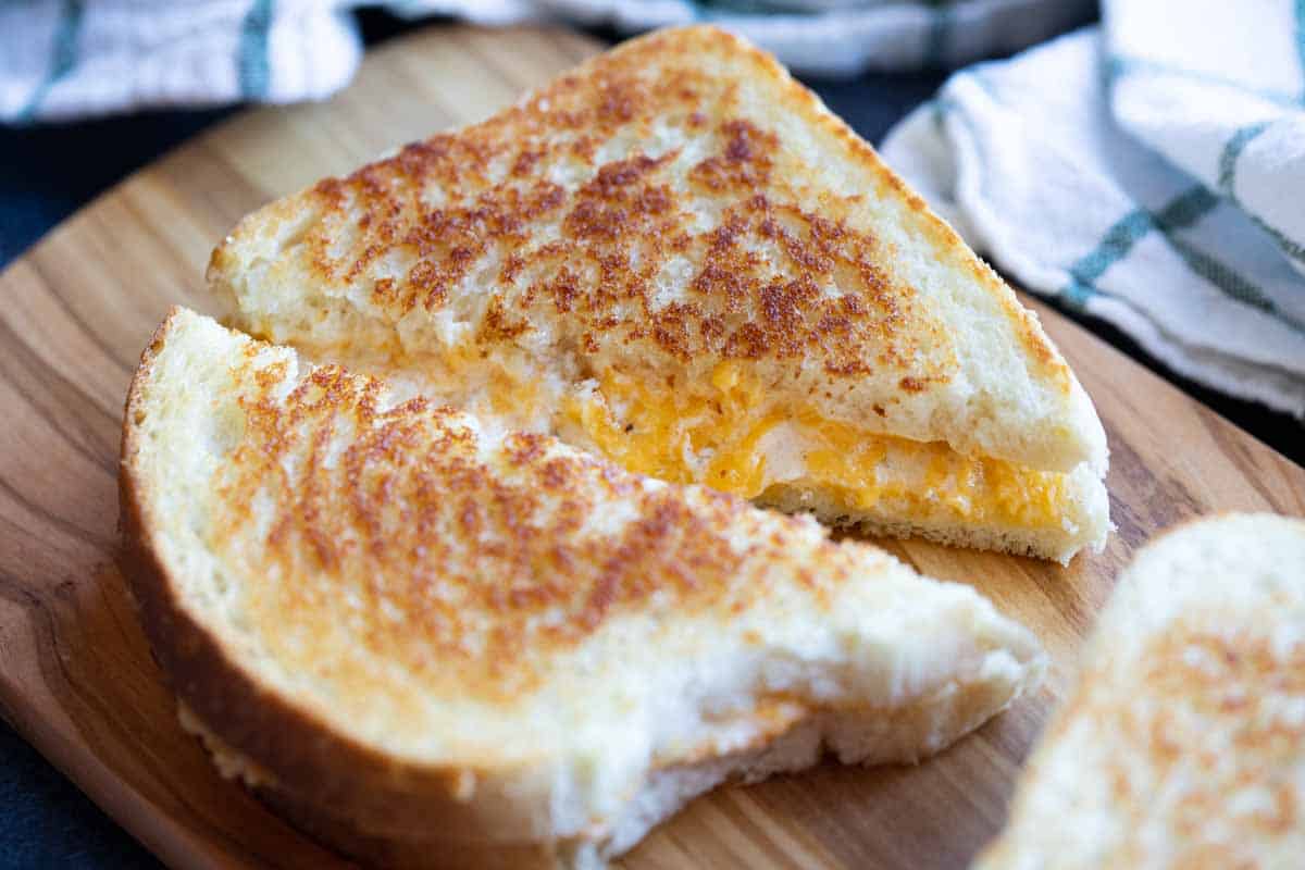 sliced grilled cheese sandwich on a cutting board