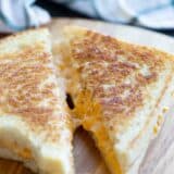 sliced grilled cheese sandwich showing gooey cheese