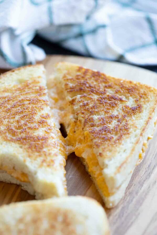 sliced grilled cheese sandwich showing gooey cheese