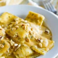 ravioli in a bowl topped with pumpkin pasta sauce