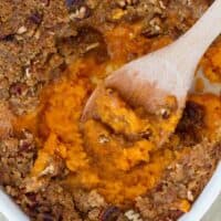 overhead view of sweet potato casserole with wooden spoon