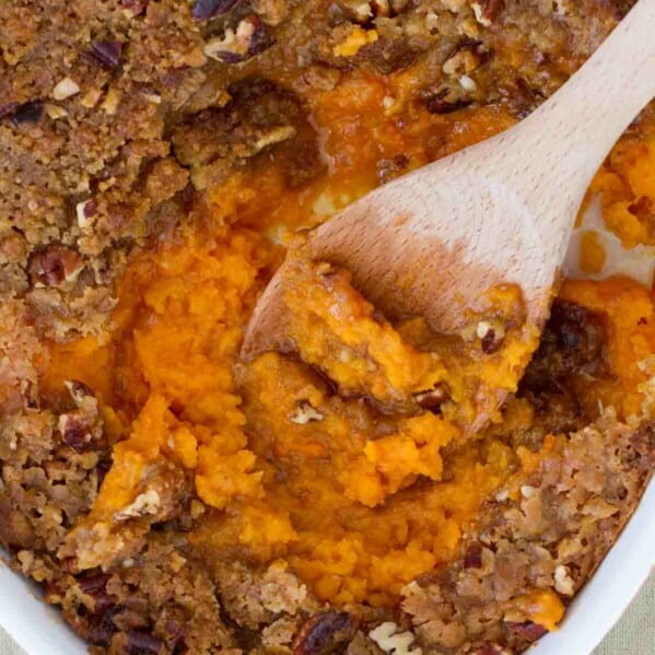overhead view of sweet potato casserole with wooden spoon