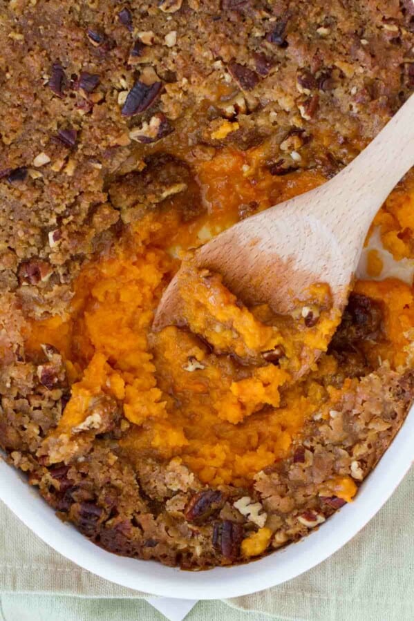 overhead view of sweet potato casserole with wooden spoon