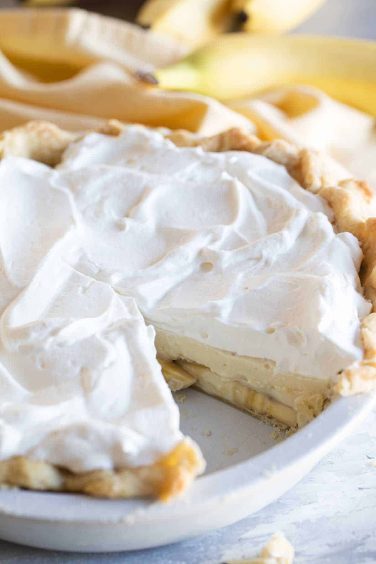 whole banana cream pie with slice taken