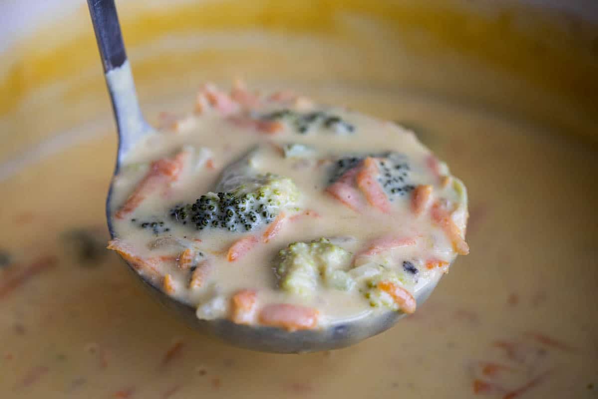 pot of broccoli cheddar soup with ladle full of soup