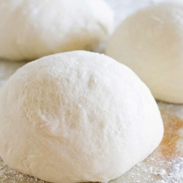 balls of homemade pizza dough on a counter