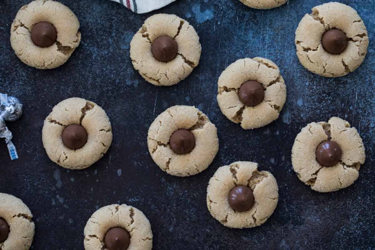 A classic cookie - these Peanut Butter Blossoms are easy to make and perfect for you holiday cookie plate or cookie exchange. They make a great Christmas cookie, but they are also great all year round! overhead view of peanut butter blossoms with hershey's kiss