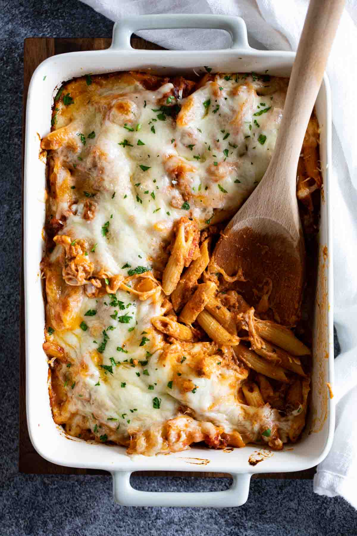 overhead view of Penne Pasta Bake recipe with wooden serving spoon