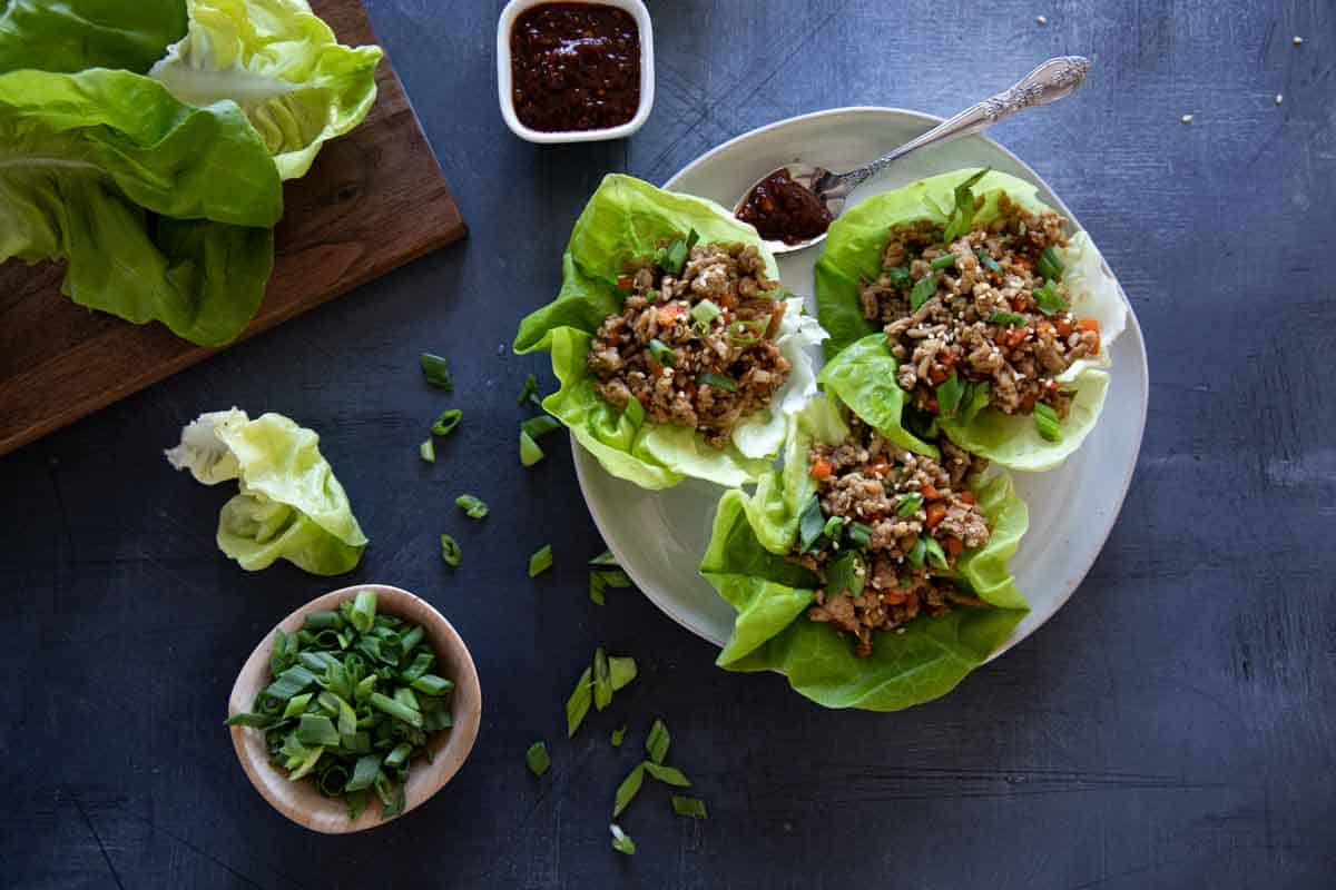 chicken lettuce wraps on a plate with ingredients close by