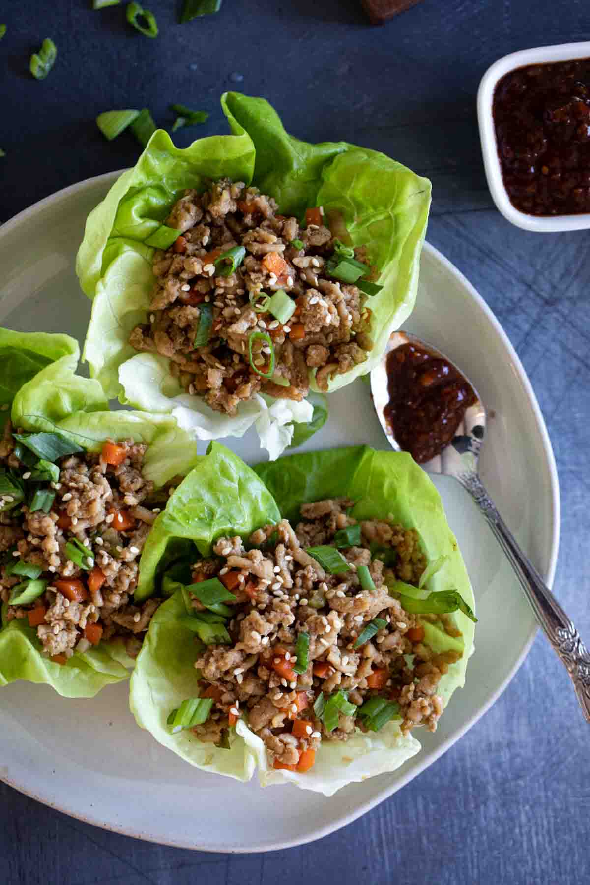 overhead view of chicken lettuce wraps with chili sauce