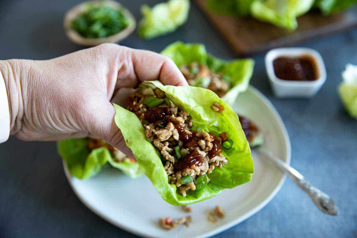 hand holding a chicken lettuce wrap