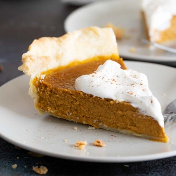 slice of pumpkin pie with whipped cream on a plate