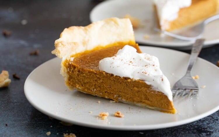 slice of pumpkin pie with whipped cream on a plate