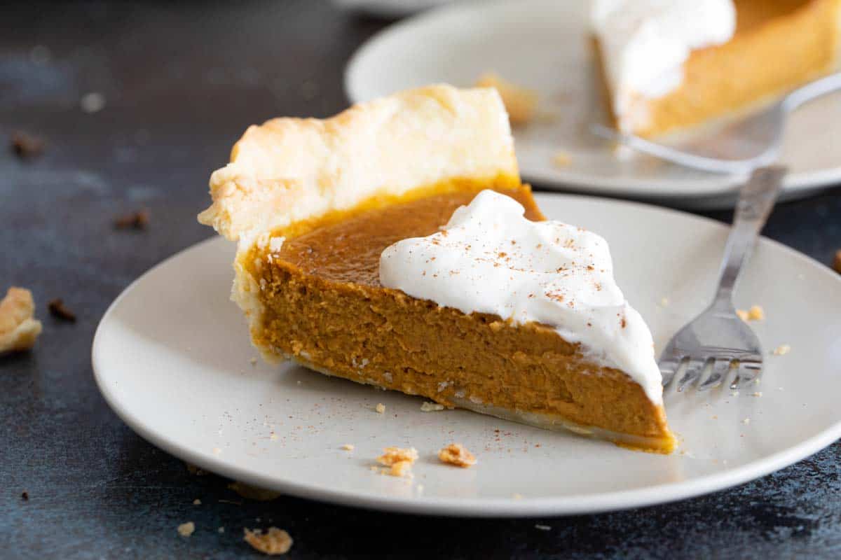 slice of pumpkin pie with whipped cream on a plate