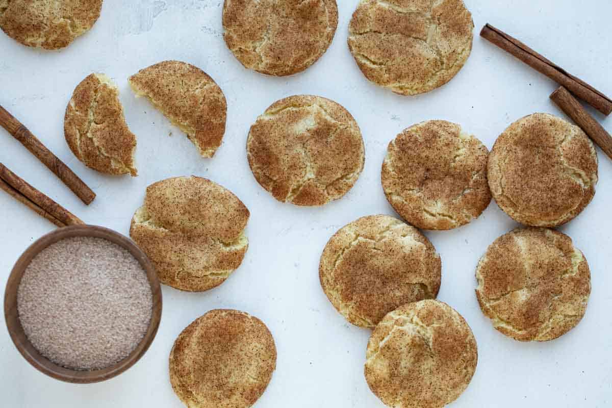 snickerdoodles with cinnamon sticks and bowl of cinnamon sugar