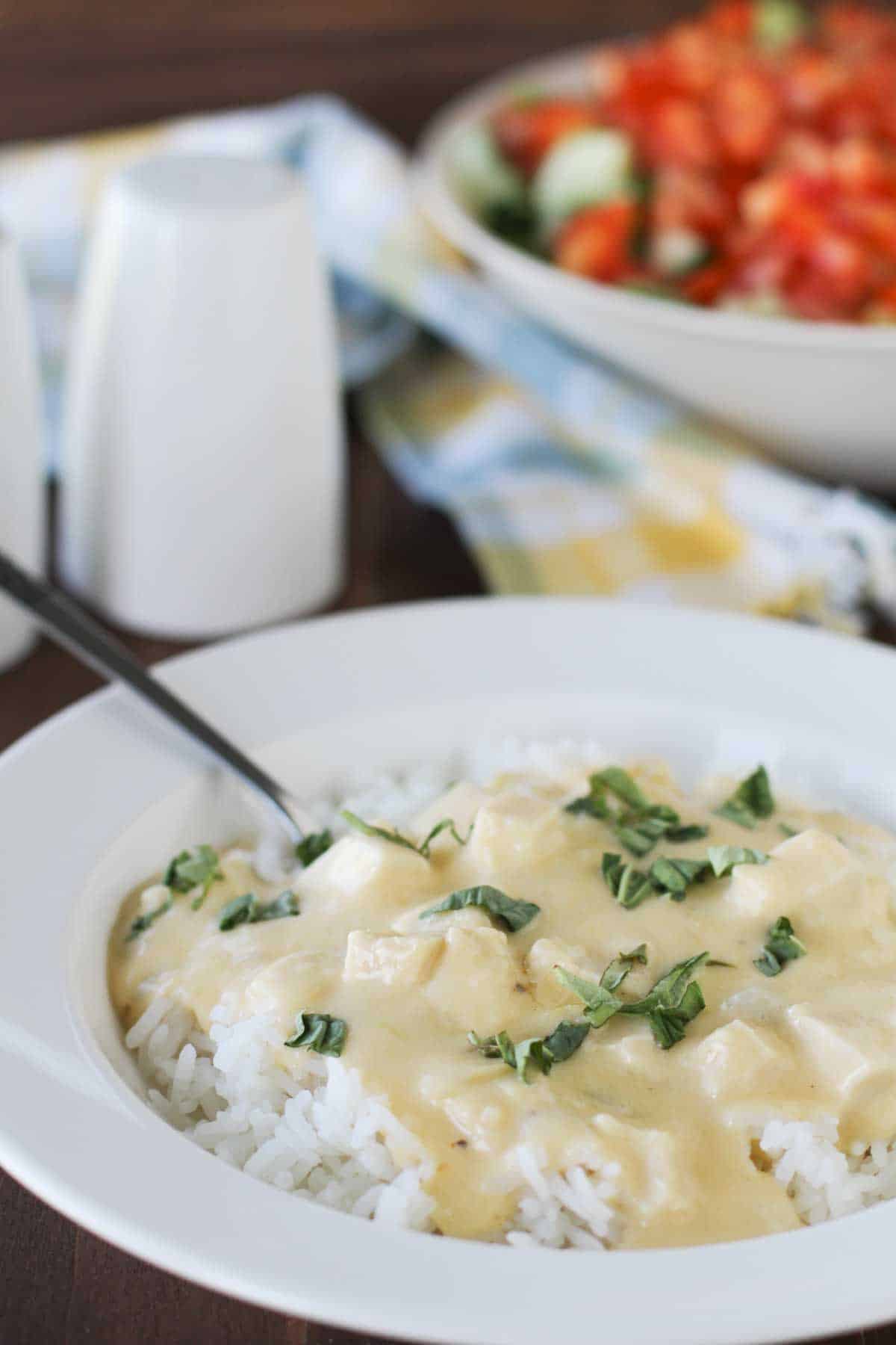 This Cheesy Sour Cream Chicken is an easy chicken dinner that is made in one pot, with a cheesy sour cream sauce. Cheesy Sour Cream Chicken served over rice and topped with basil.