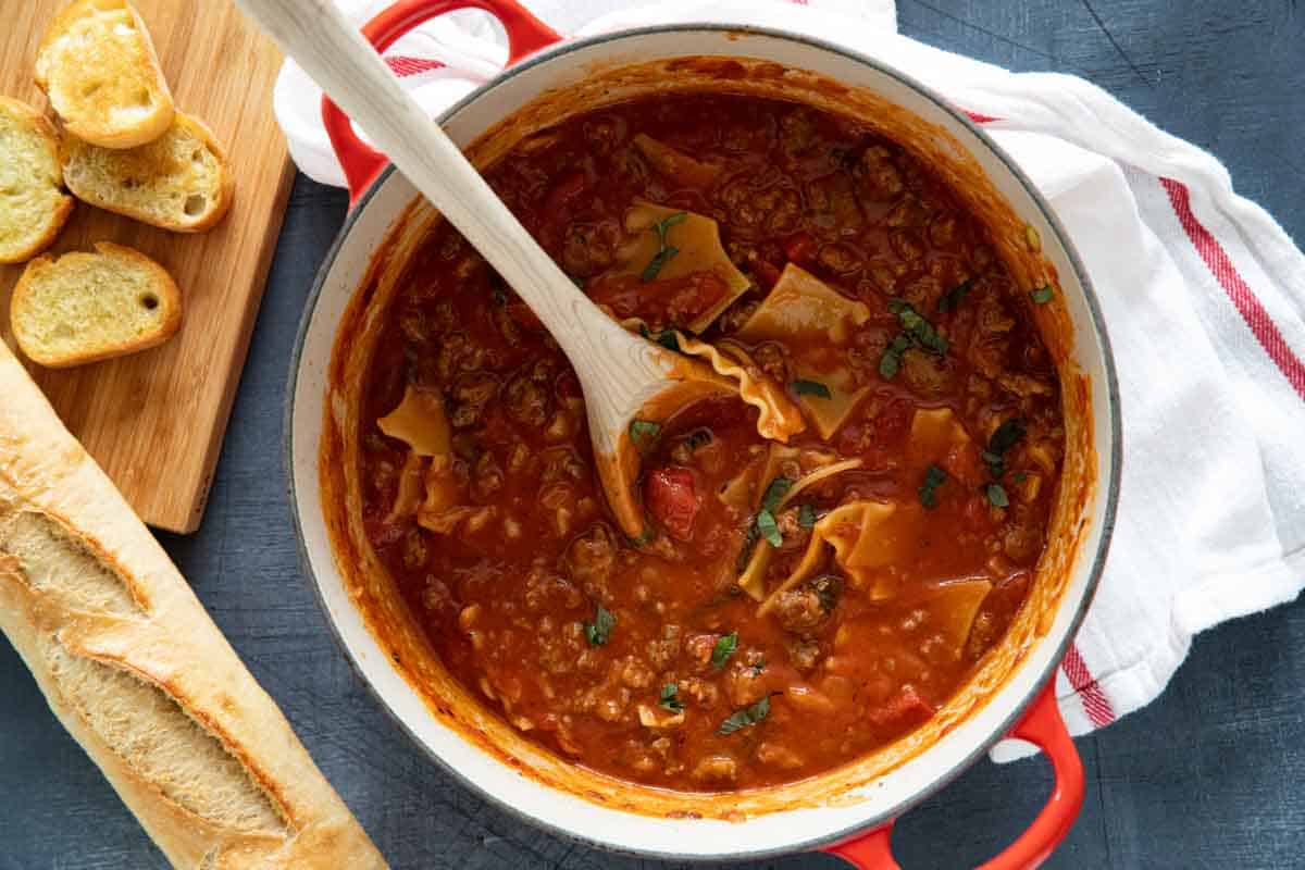 Dutch oven with lasagna soup with bread on the side