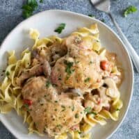 overhead view of a plate with buttered noodles topped with mustard chicken