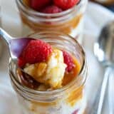 spoonful of rice pudding with caramel and raspberries showing texture.