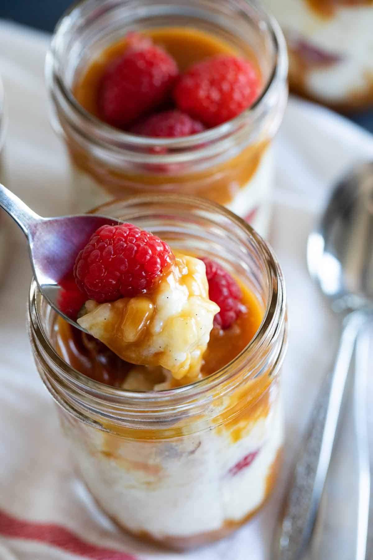 spoonful of rice pudding with caramel and raspberries showing texture.