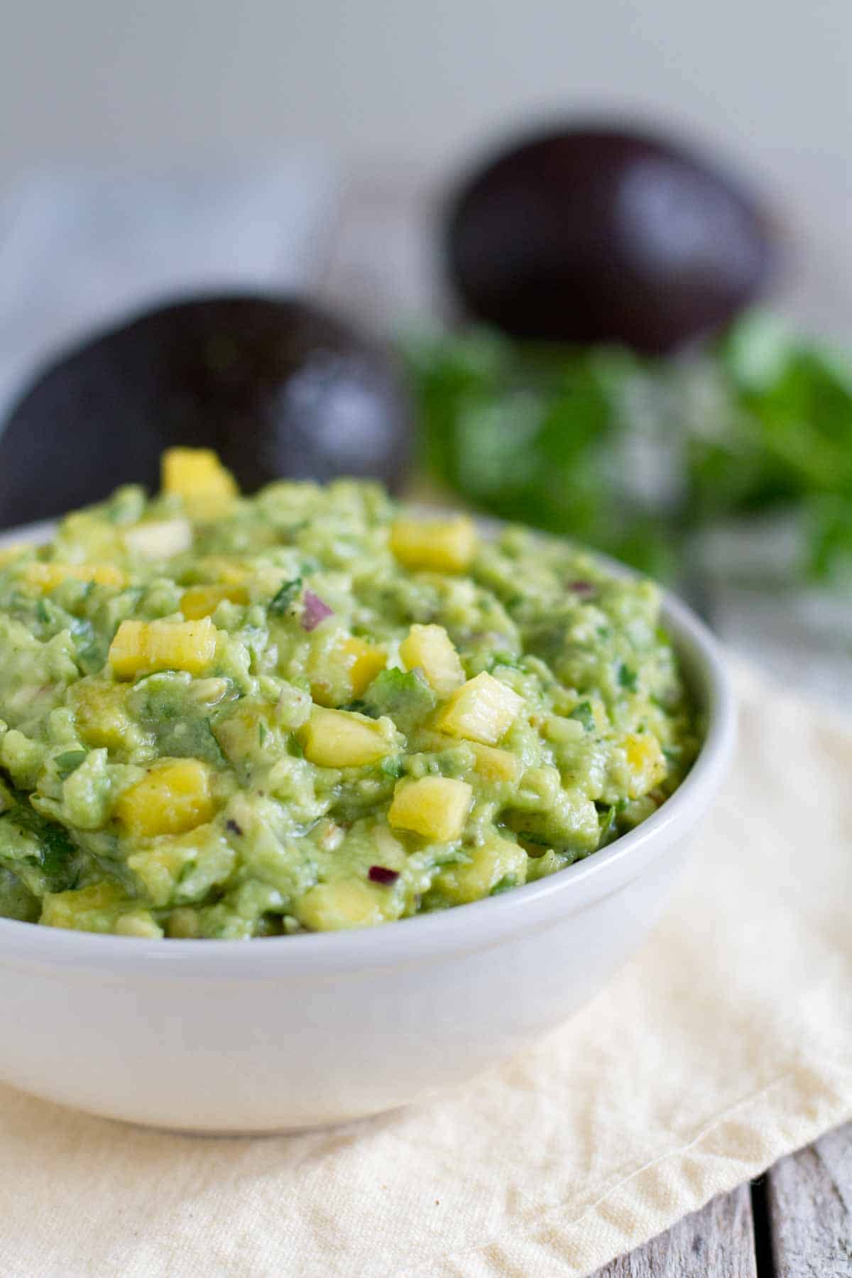 Bowl of Tropical Guacamole topped with pineapple.