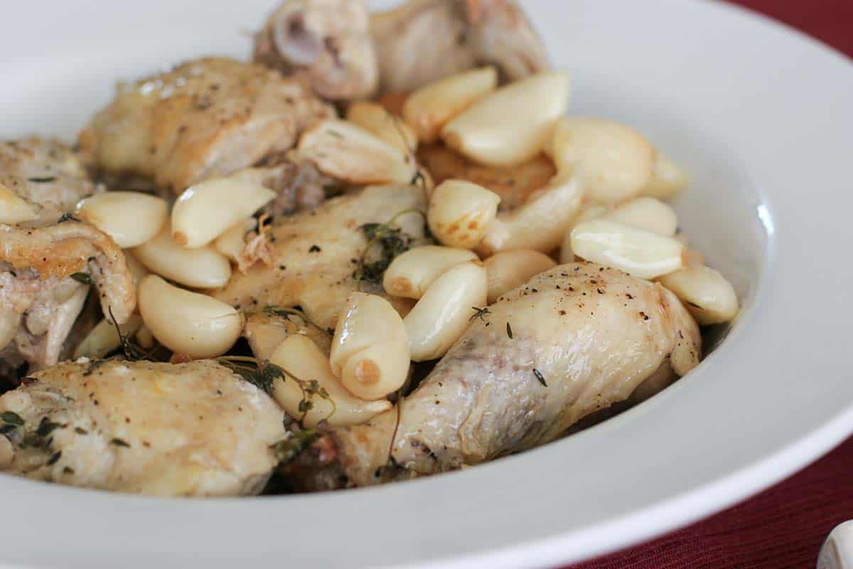 Chicken with 40 cloves of garlic in a serving dish.