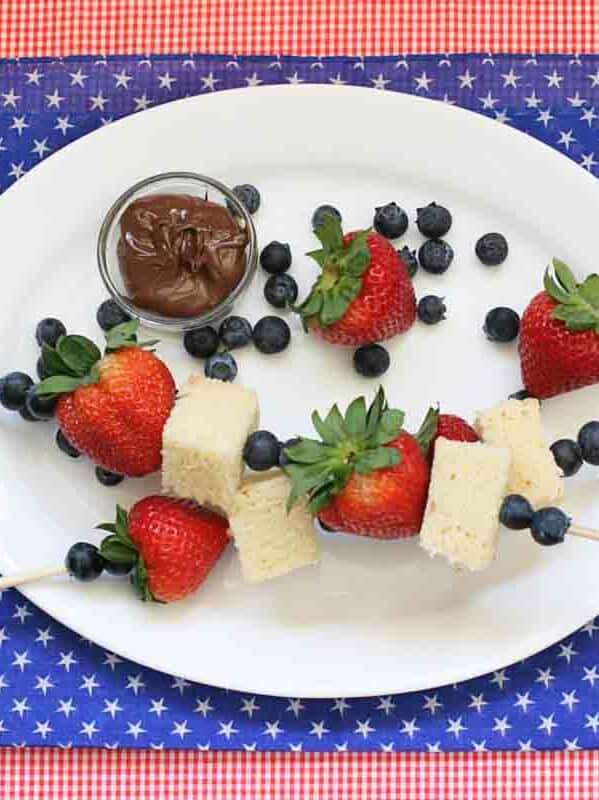 overhead view of 2 4th of July Dessert Kabobs with pound cake, blueberries and strawberries