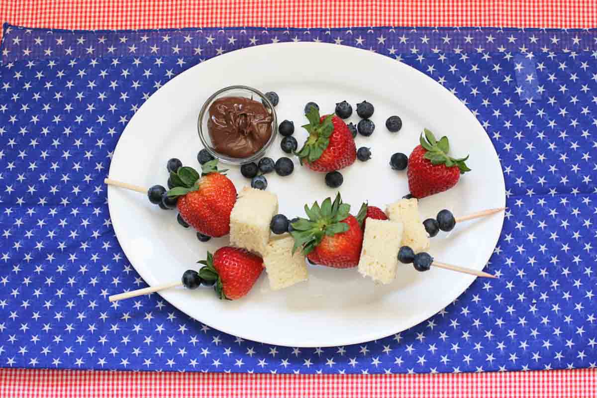 overhead view of 2 4th of July Dessert Kabobs with pound cake, blueberries and strawberries