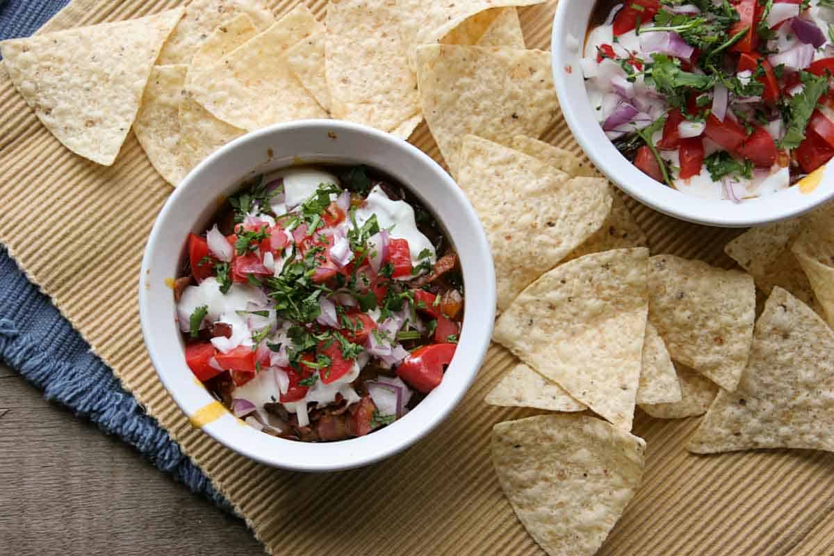 overhead view of 7 layer chili dog dip surrounded by tortilla chips