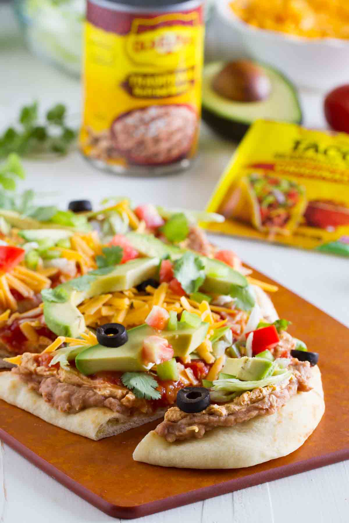 7 layer flatbread cut into slices with ingredients in the background