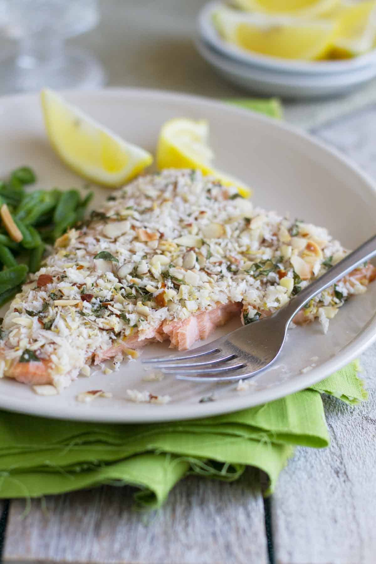 Almond Crusted Salmon on a plate with part eaten to show texture