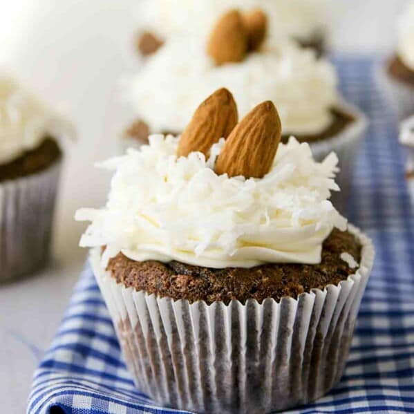 Almond Joy Cupcakes in a row on top of blue and white fabric.