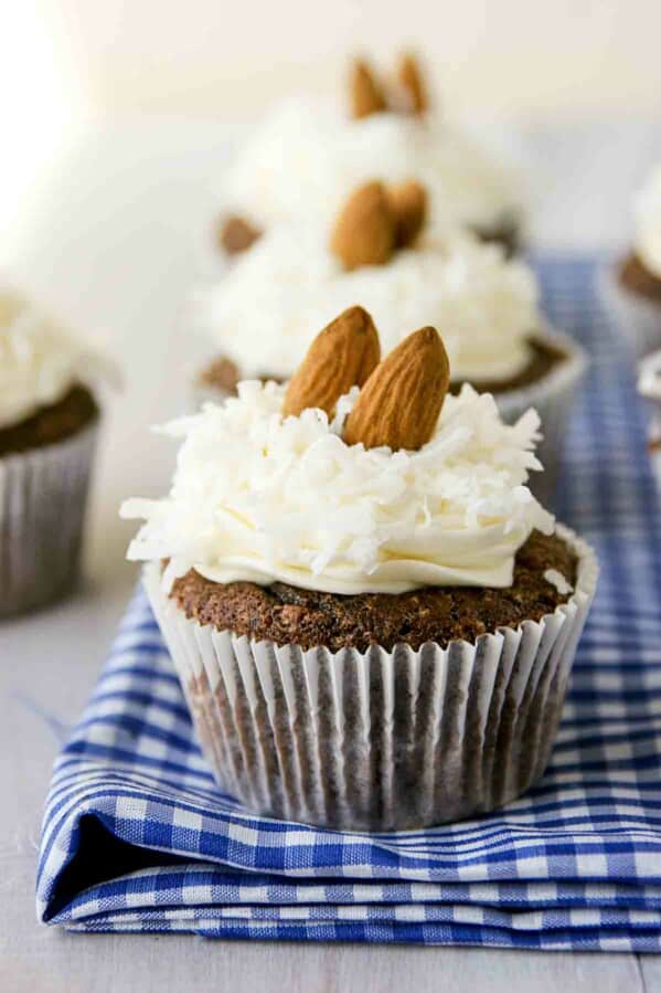 Almond Joy Cupcakes in a row on top of blue and white fabric.